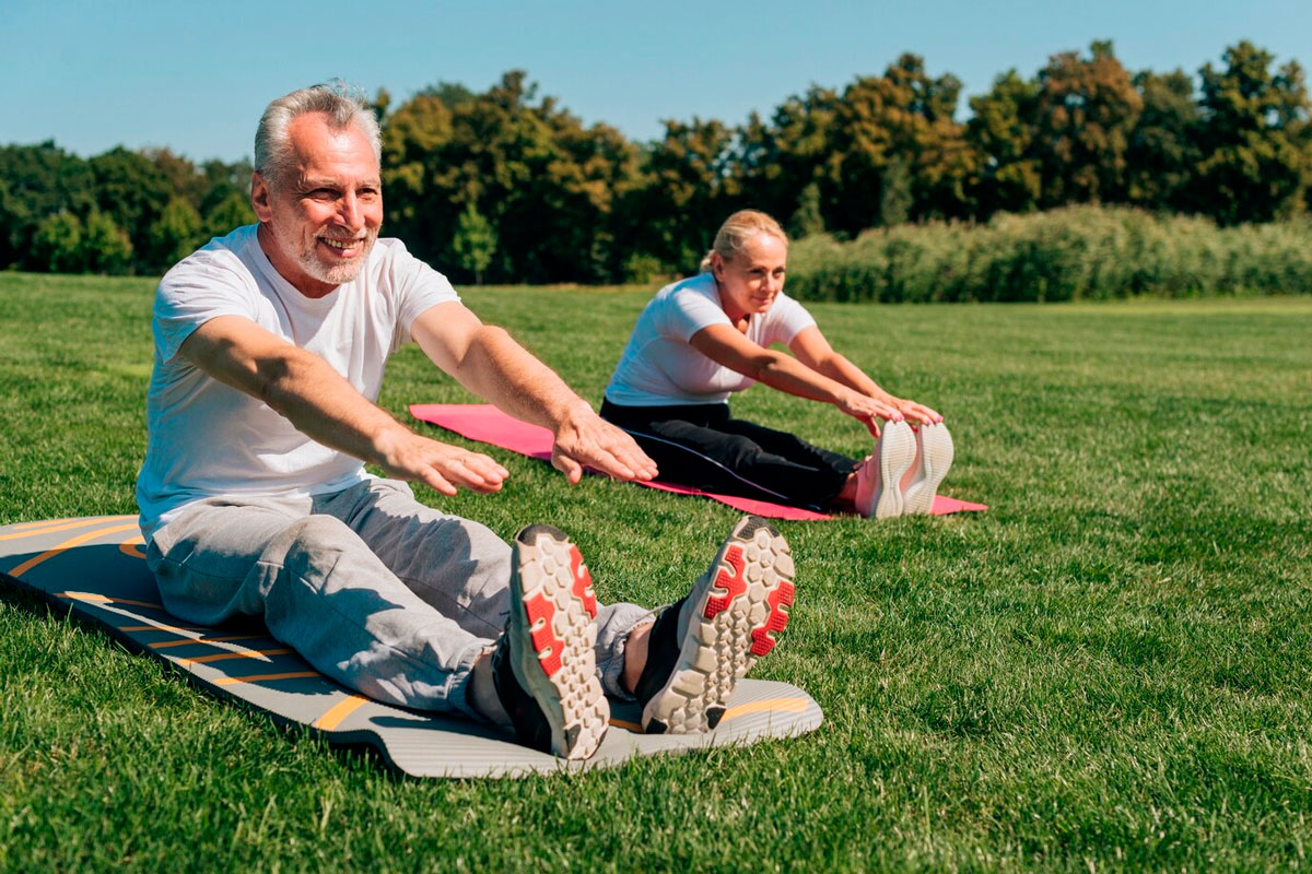 dos personas realizando estiramientos en el césped