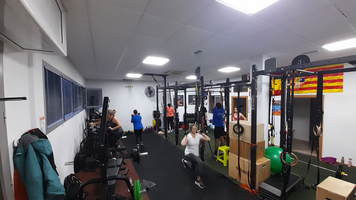 Instalaciones CENTRO FISICO, varias bicicletas y pesas. También se ven a personas realizando ejercicios con pesas